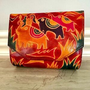 Mediterranean Trading Co. red, leather crossbody bag with elephant etching.